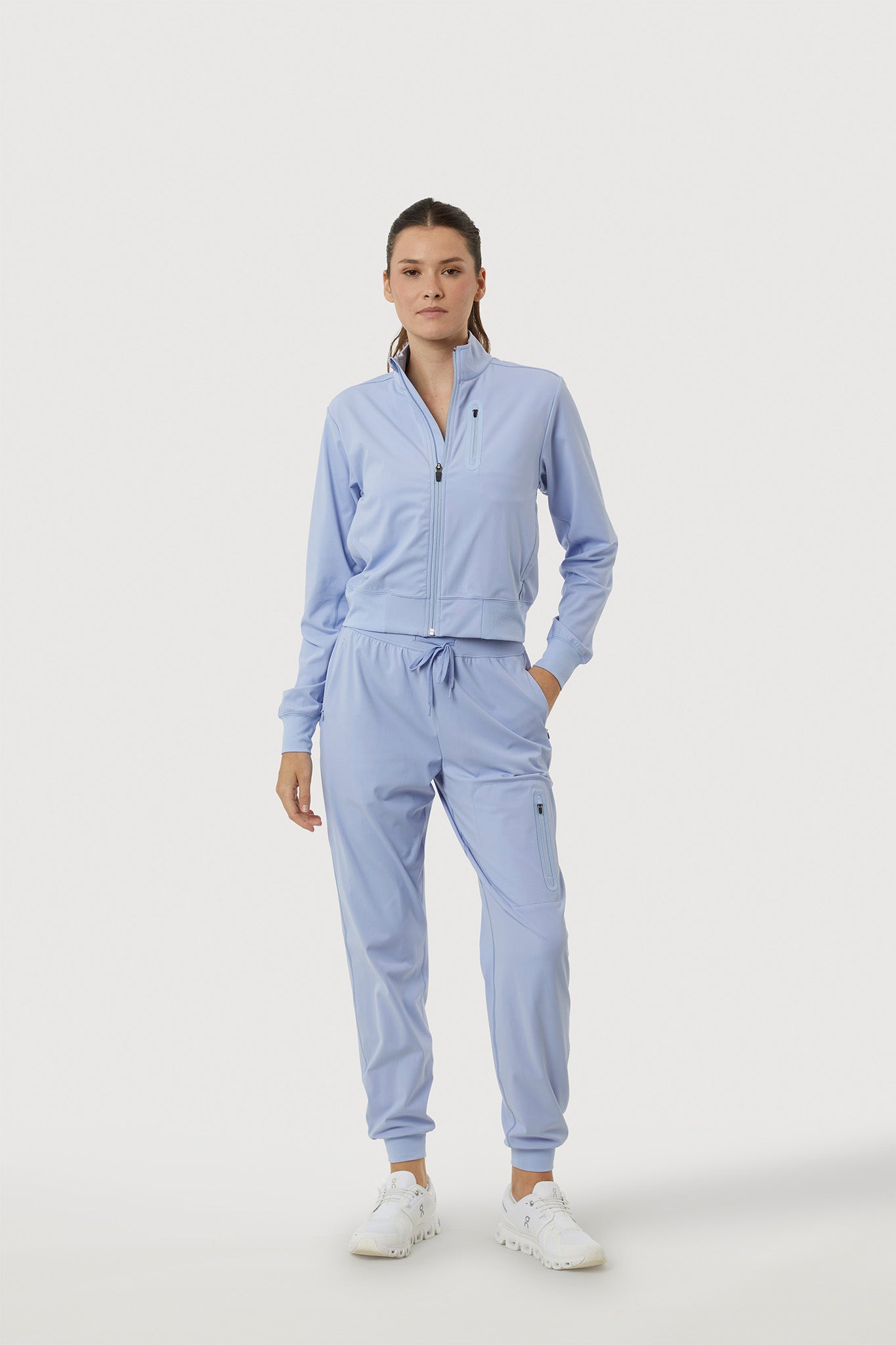 Woman wearing a light blue tracksuit on a white background