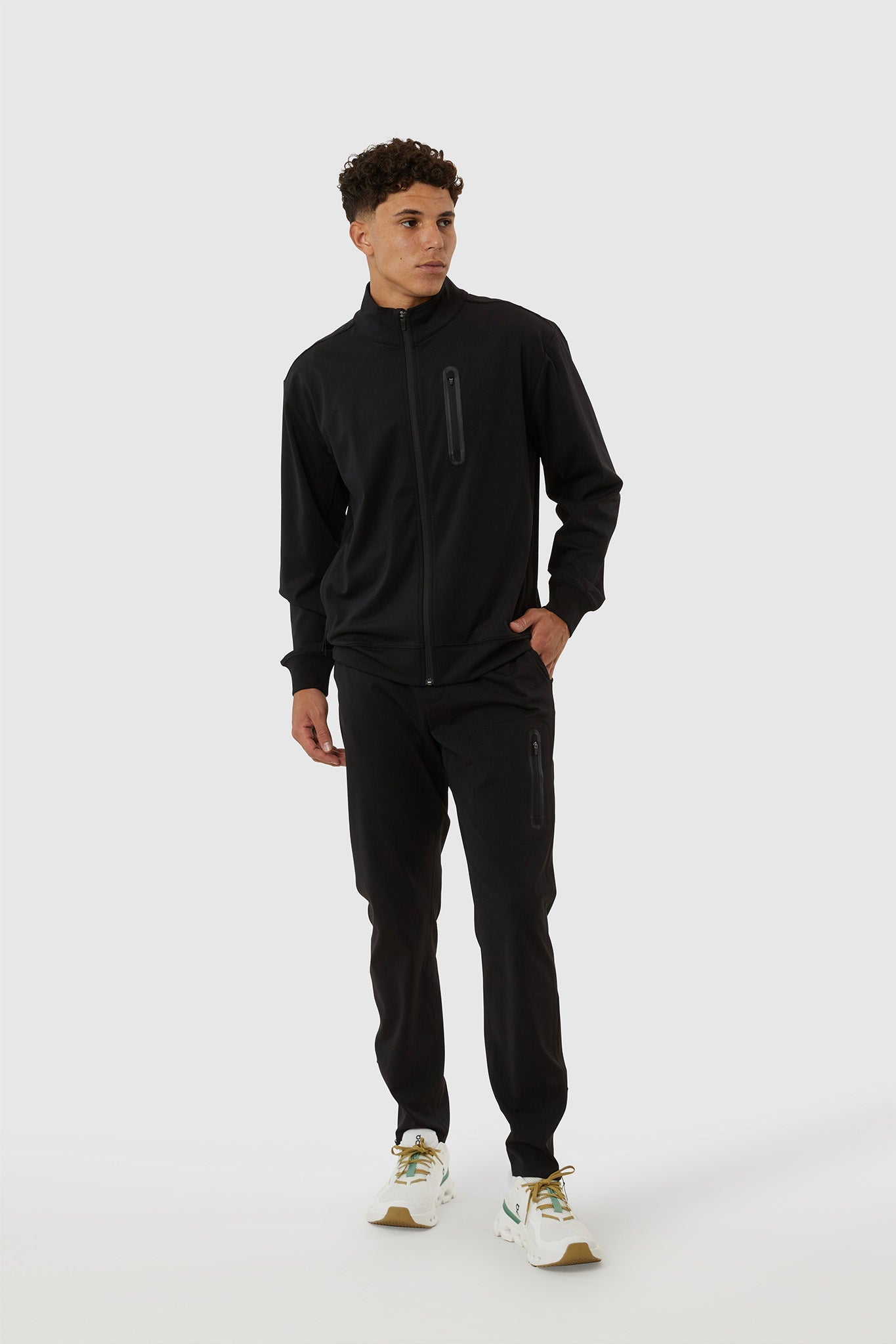 Man wearing a black tracksuit on a white background