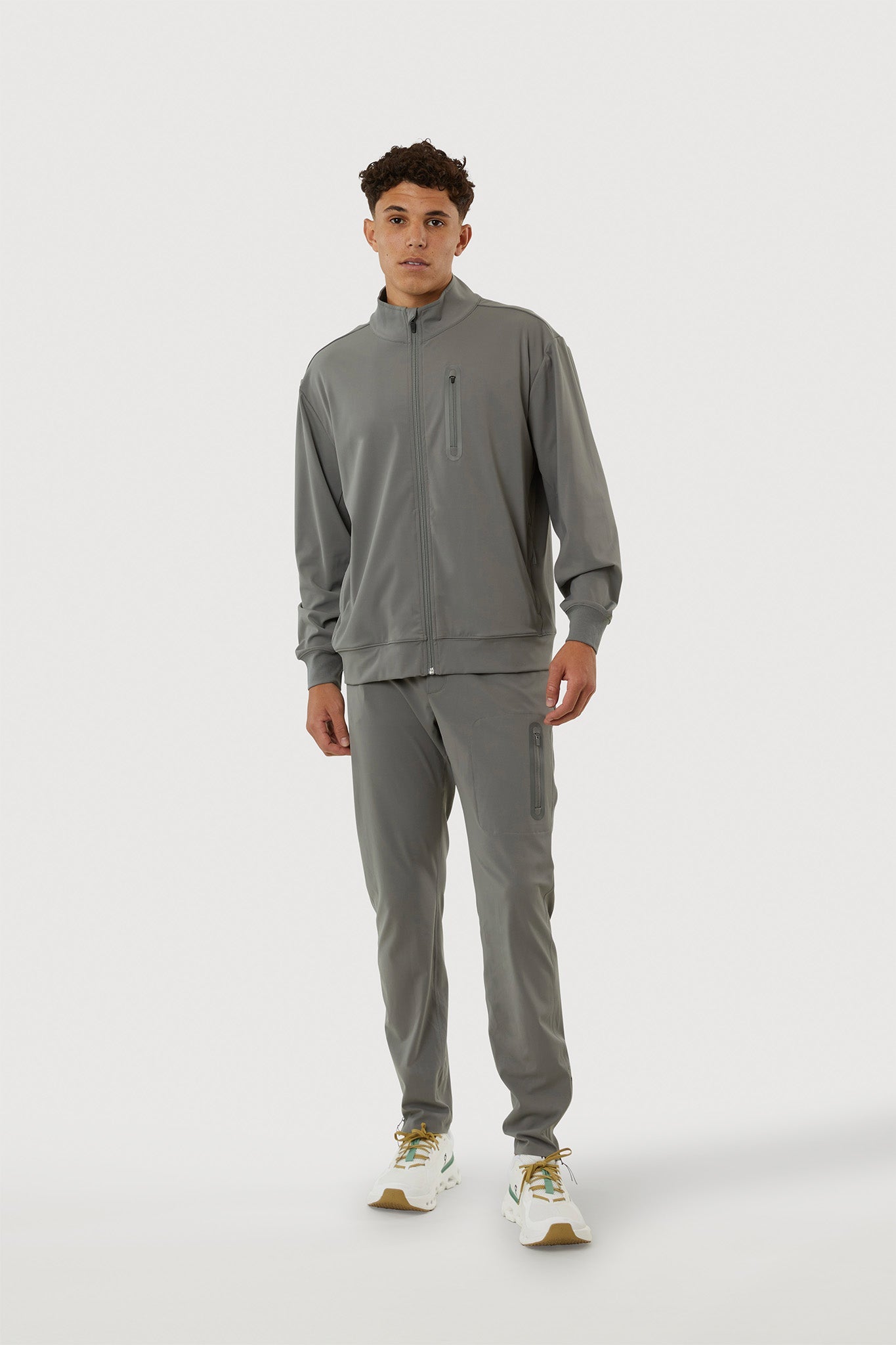Man wearing a gray tracksuit on a white background