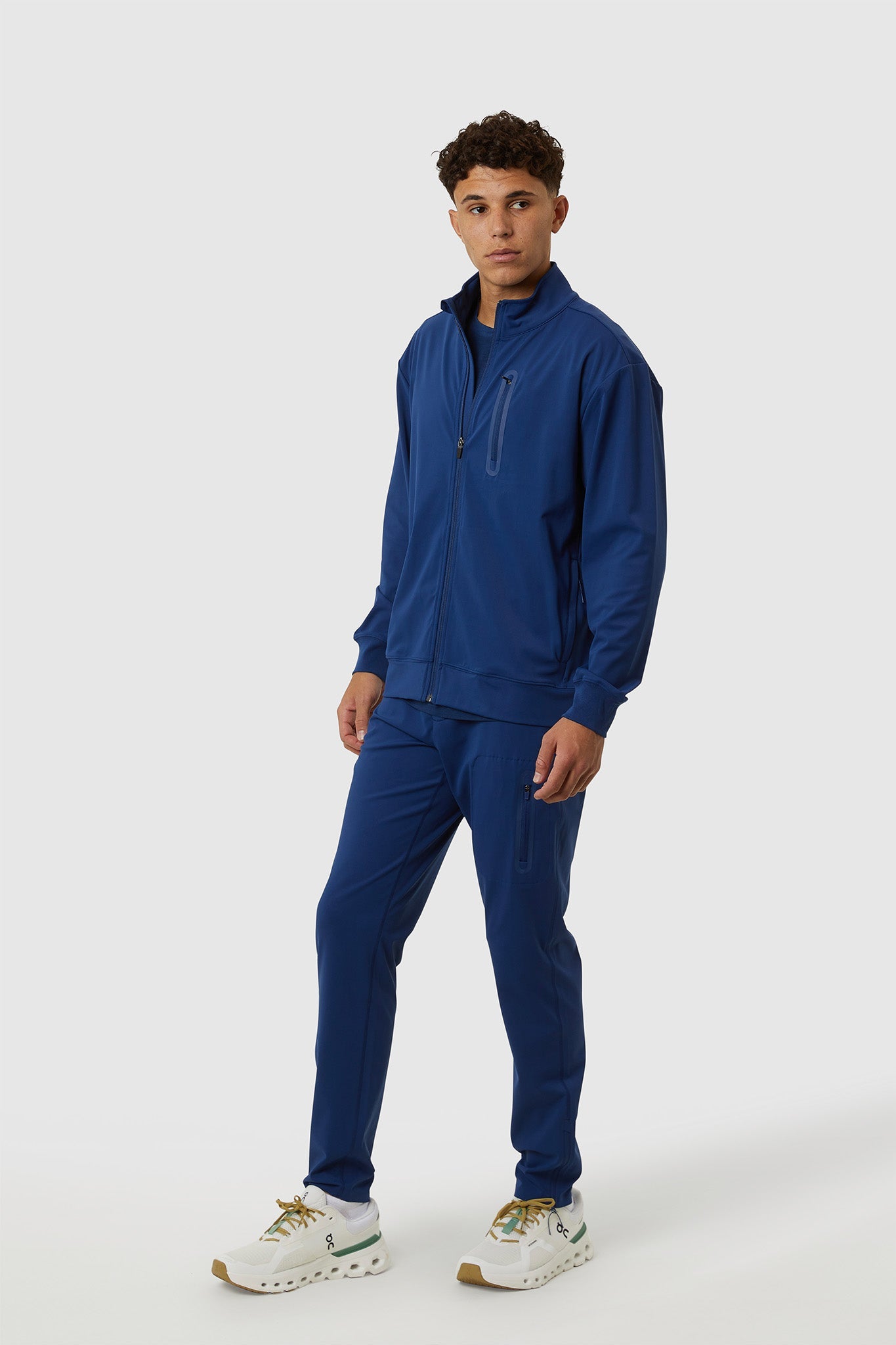 Man wearing a blue tracksuit on a white background