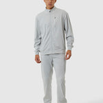Person wearing a gray tracksuit on a white background