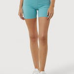 Person wearing turquoise shorts on a white background