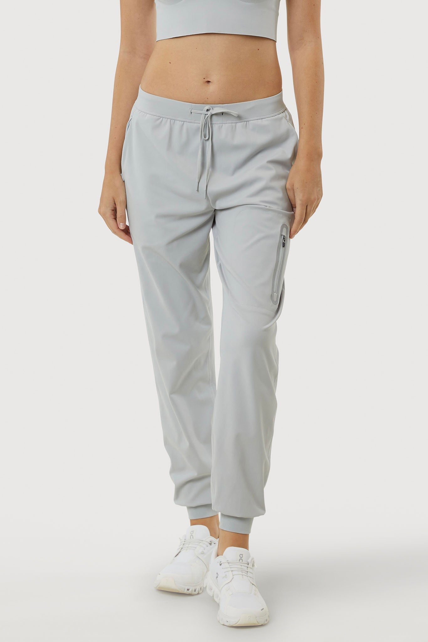 Light gray jogger pants worn by a person on a white background