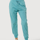 Teal jogger pants worn by a person on a white background