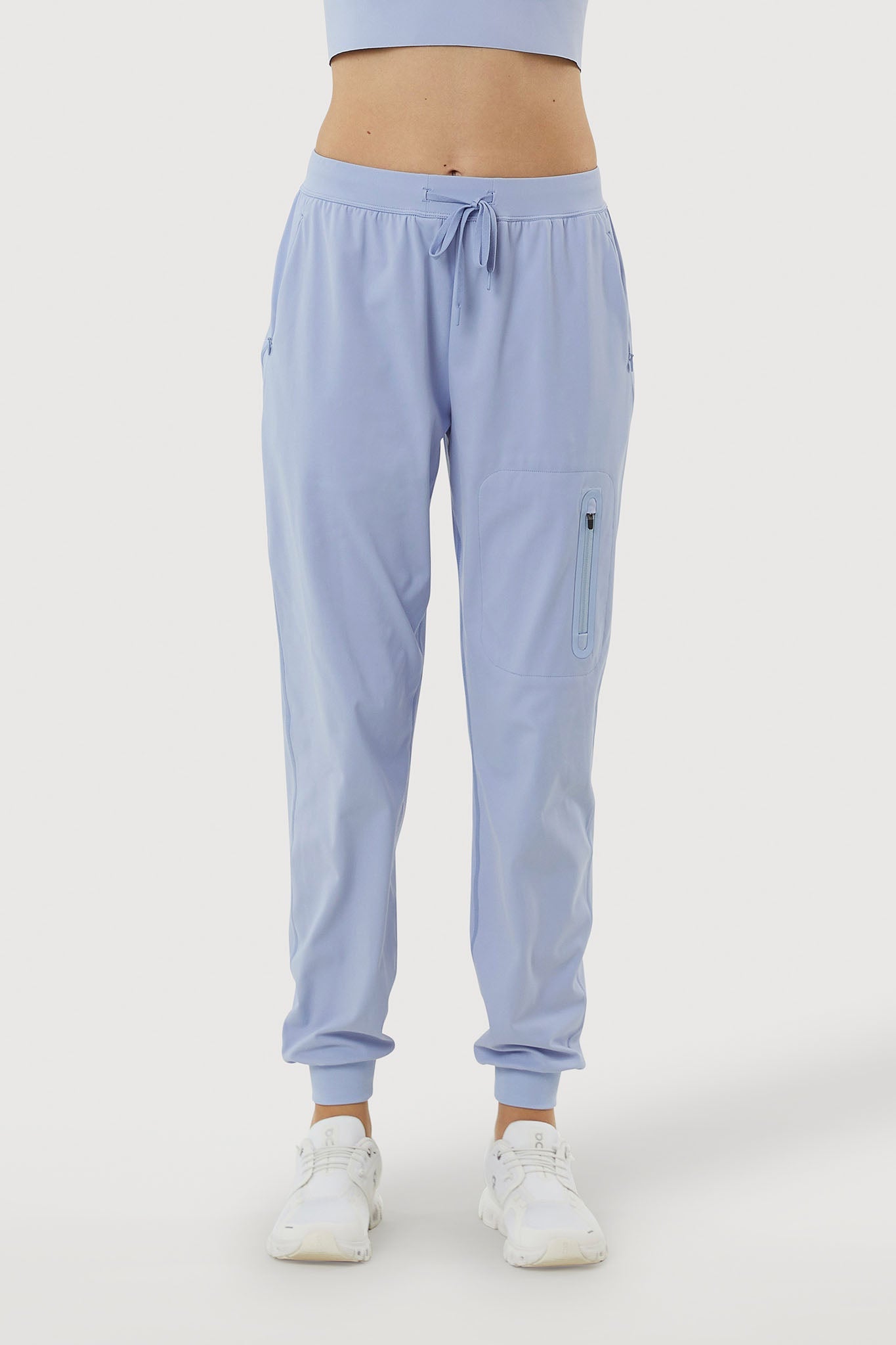 Light blue jogger pants worn by a person on a white background