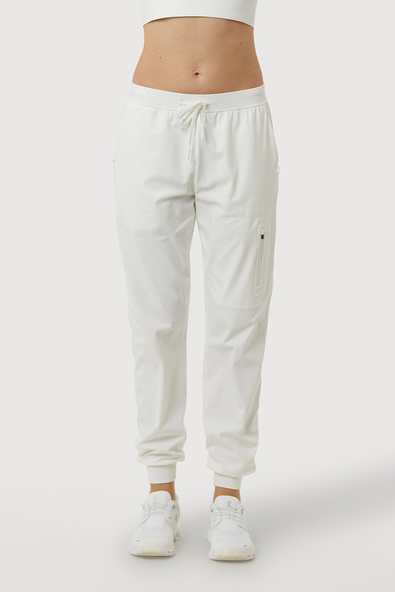 White jogger pants worn by a person on a white background