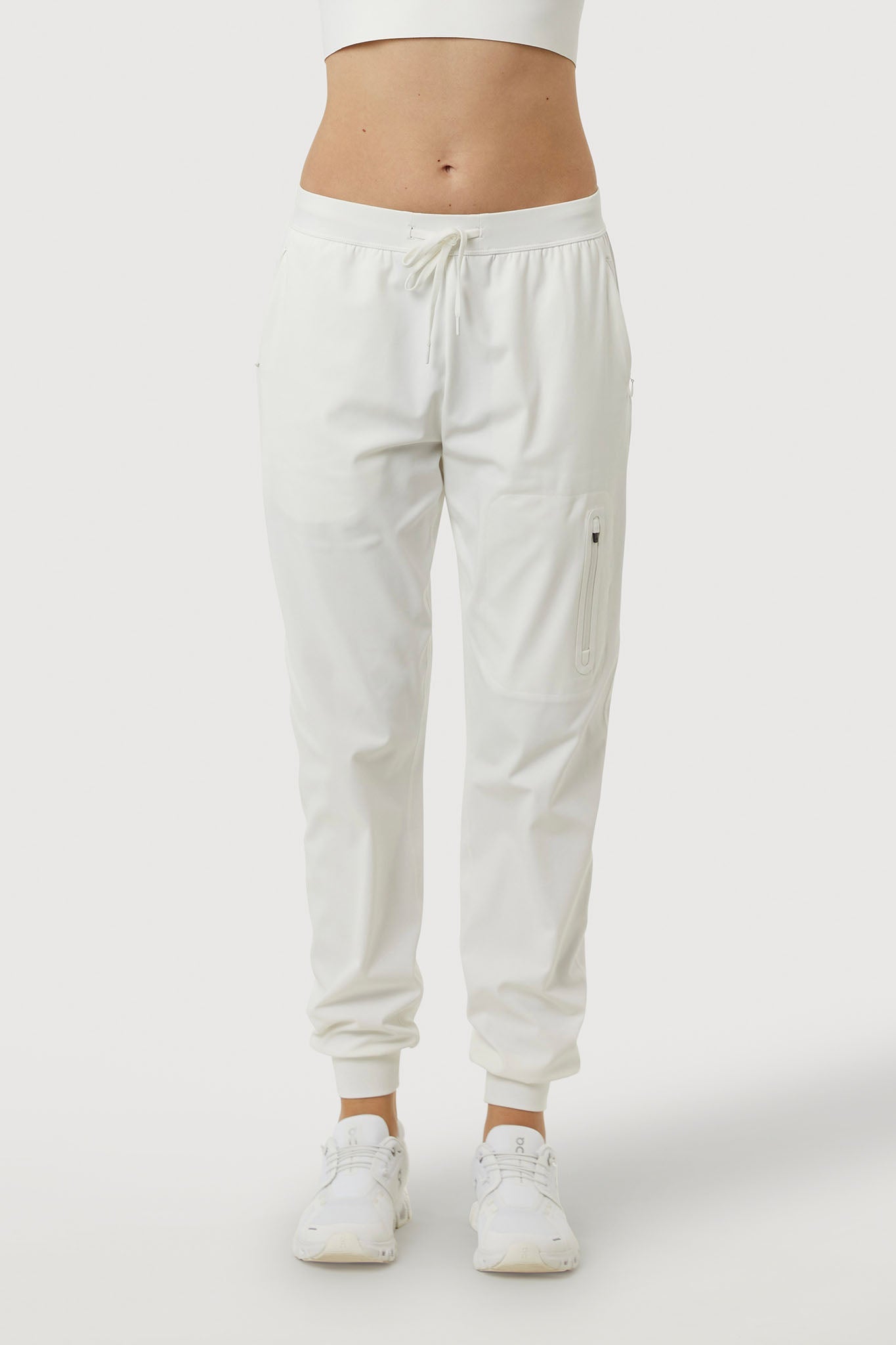 White jogger pants worn by a person on a white background