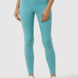 Person wearing teal leggings and a matching top on a white background