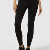 Person wearing black leggings and black sneakers on a white background