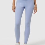 Person wearing light blue leggings and a matching top on a white background