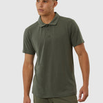 Man wearing a green polo shirt and pants on a white background