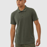 Man wearing a green polo shirt and pants on a white background