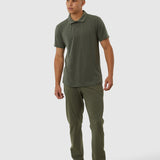 Man wearing a green polo shirt and pants on a white background