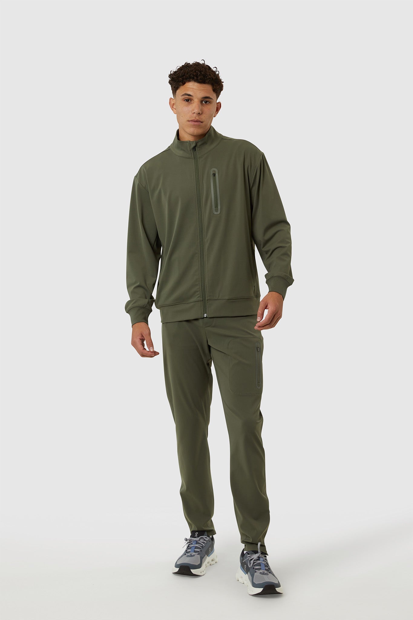 Person wearing a green tracksuit on a white background