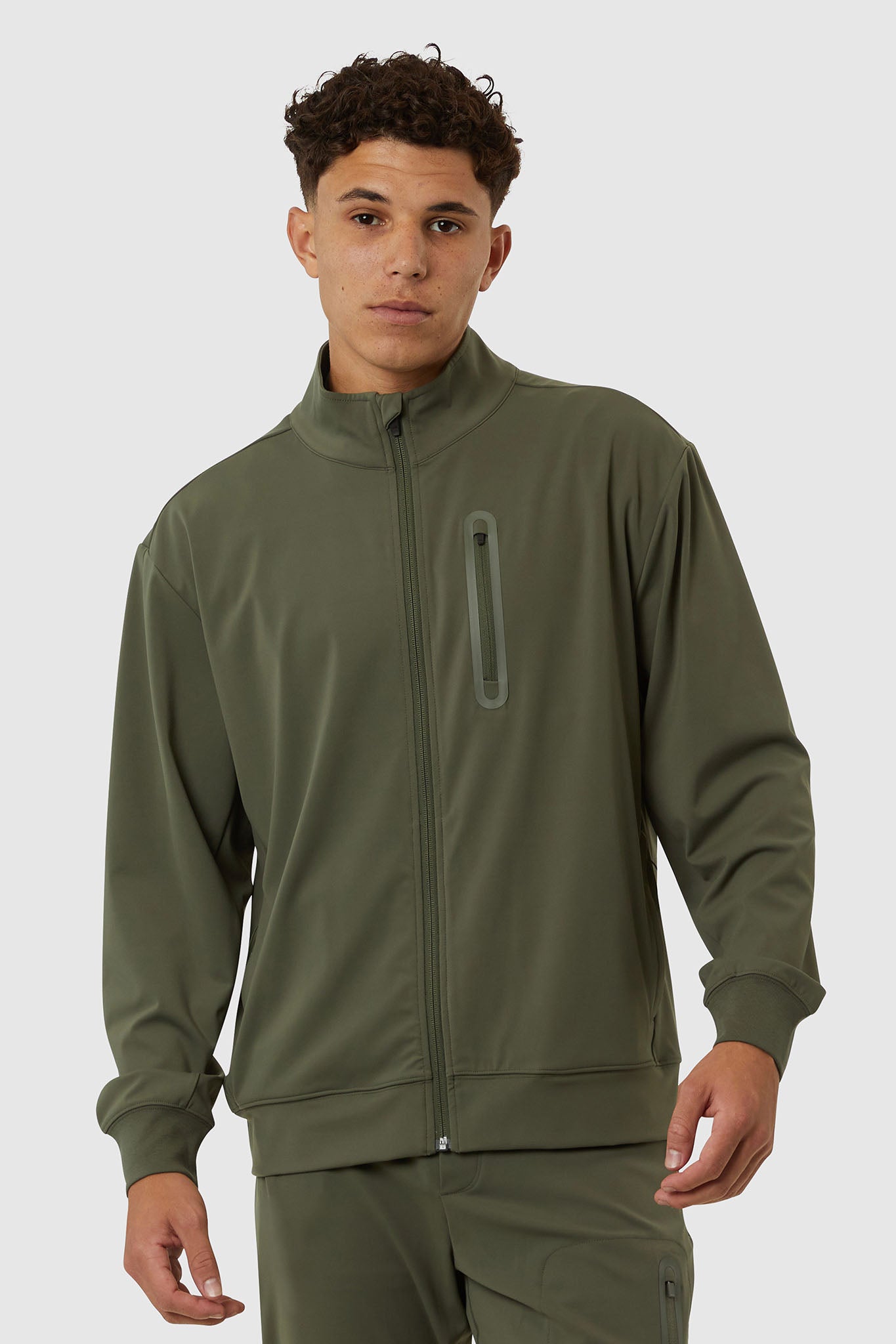 Man wearing a green tracksuit on a white background
