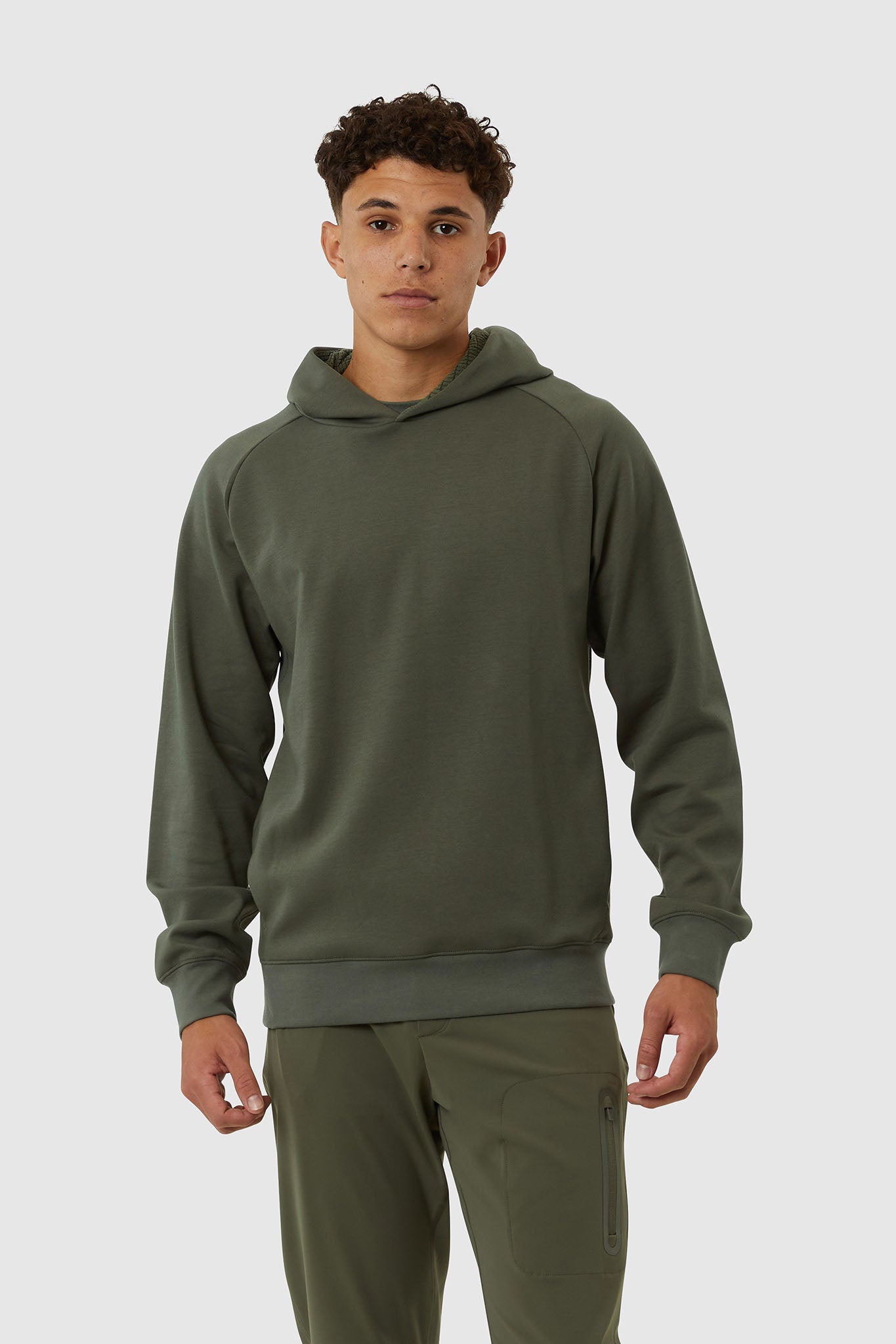 Man wearing a green hoodie and pants on a white background