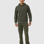 Person wearing a green hoodie and pants on a white background