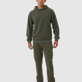 Person wearing a green hoodie and pants on a white background