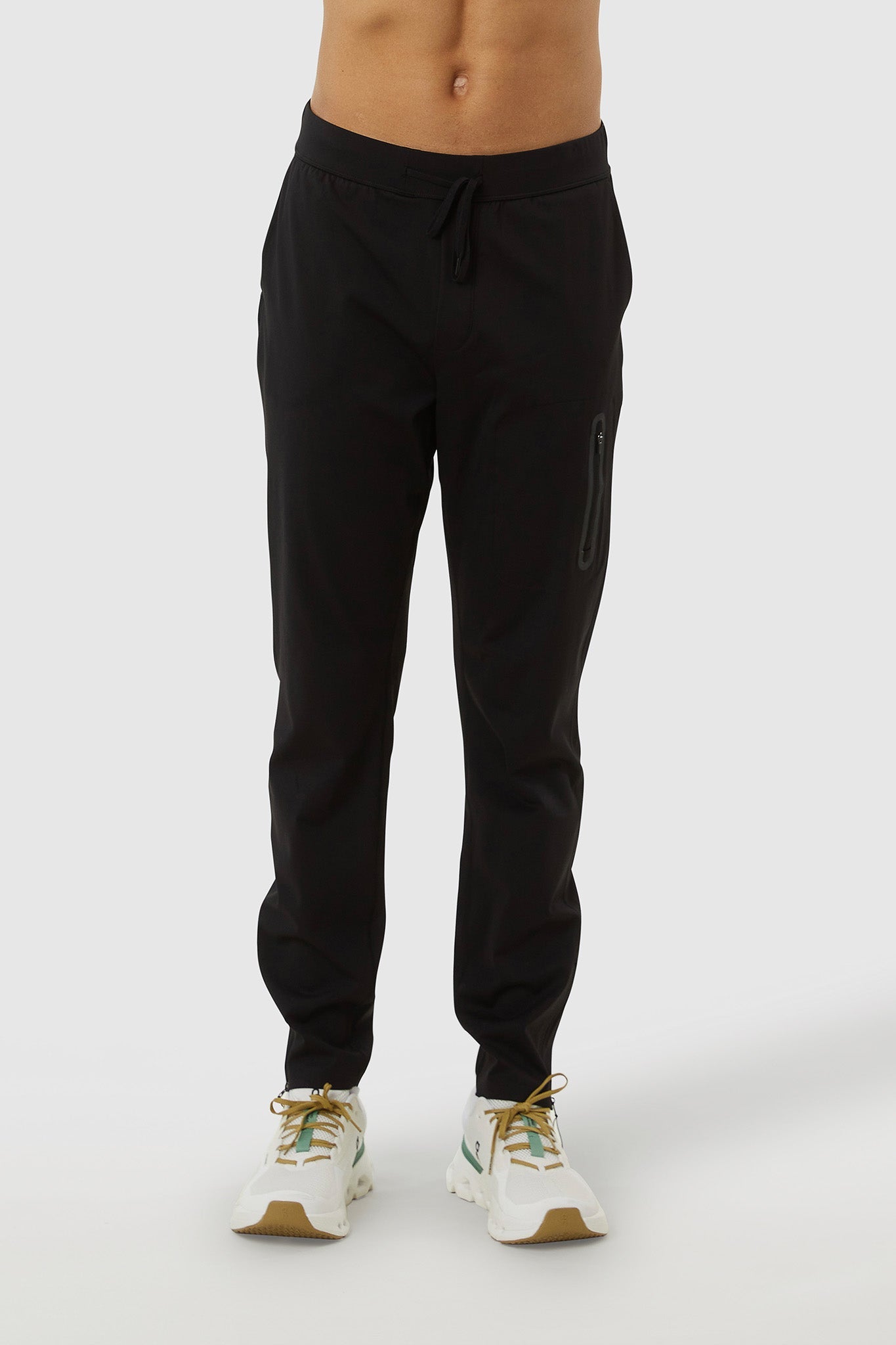 Black jogger pants worn by a person on a white background