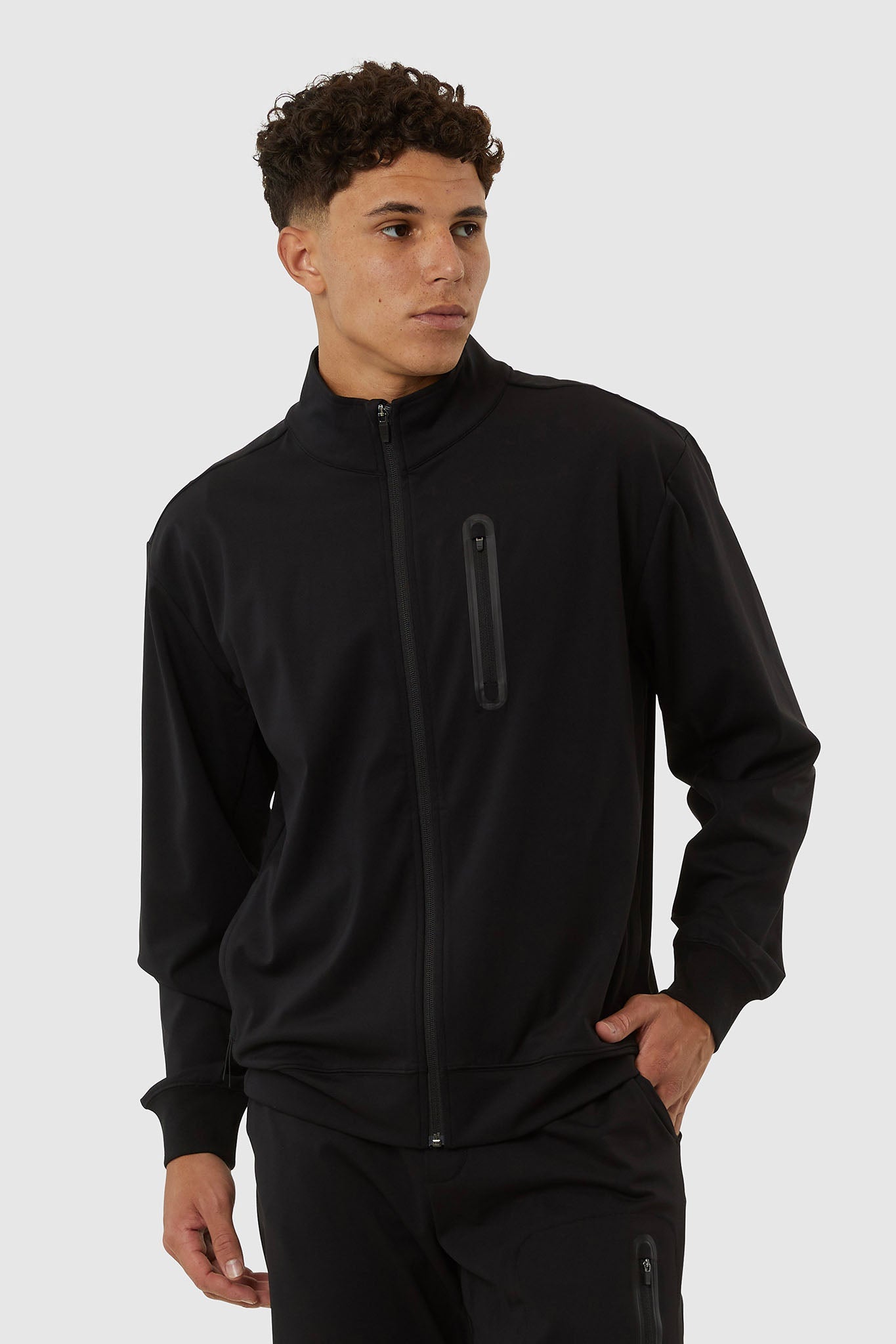 Man wearing a black jacket with zippers on a white background