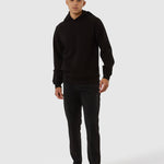 Person wearing a black hoodie and pants on a white background