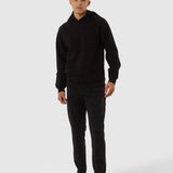 Person wearing a black hoodie and pants on a white background