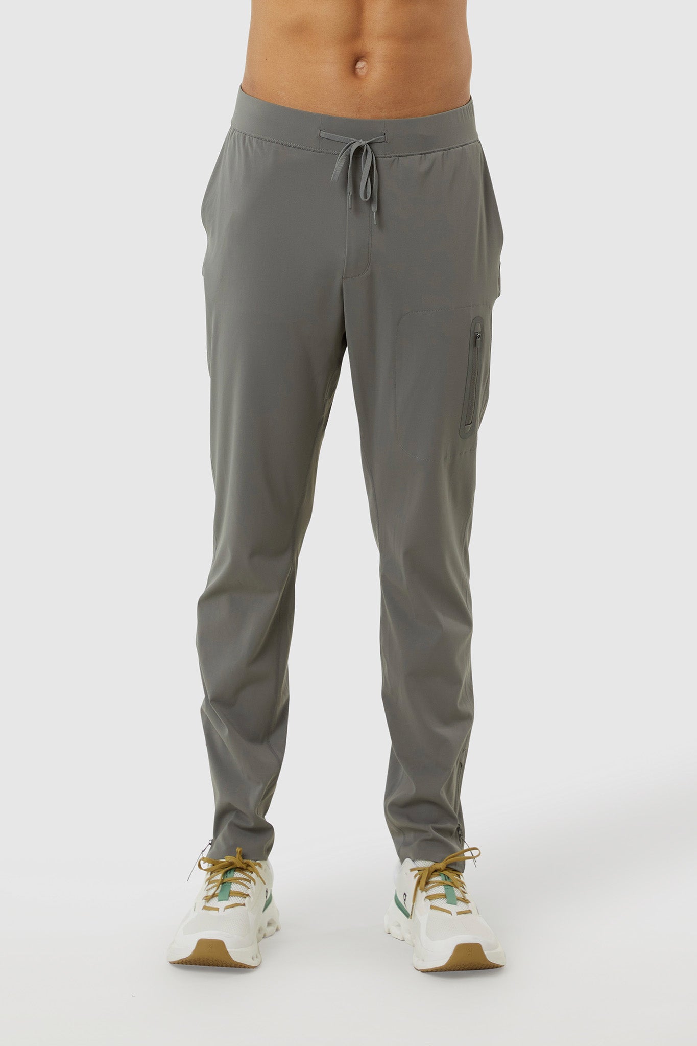 Gray jogger pants worn by a person on a white background
