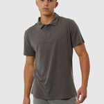 Man wearing a gray polo shirt and pants on a white background