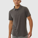 Man wearing a gray polo shirt and pants on a white background