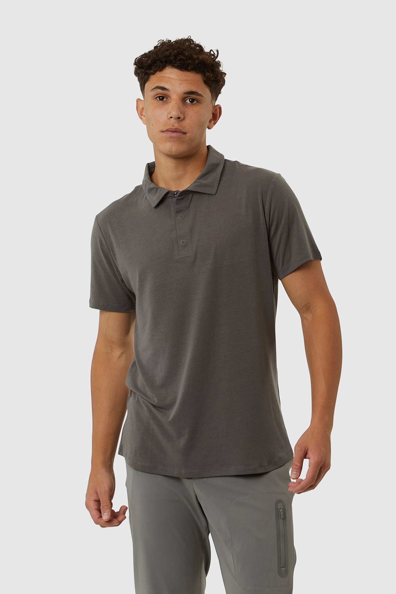 Man wearing a gray polo shirt and pants on a white background
