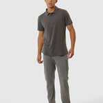 Man wearing a gray polo shirt and pants on a white background