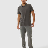 Man wearing a gray polo shirt and pants on a white background