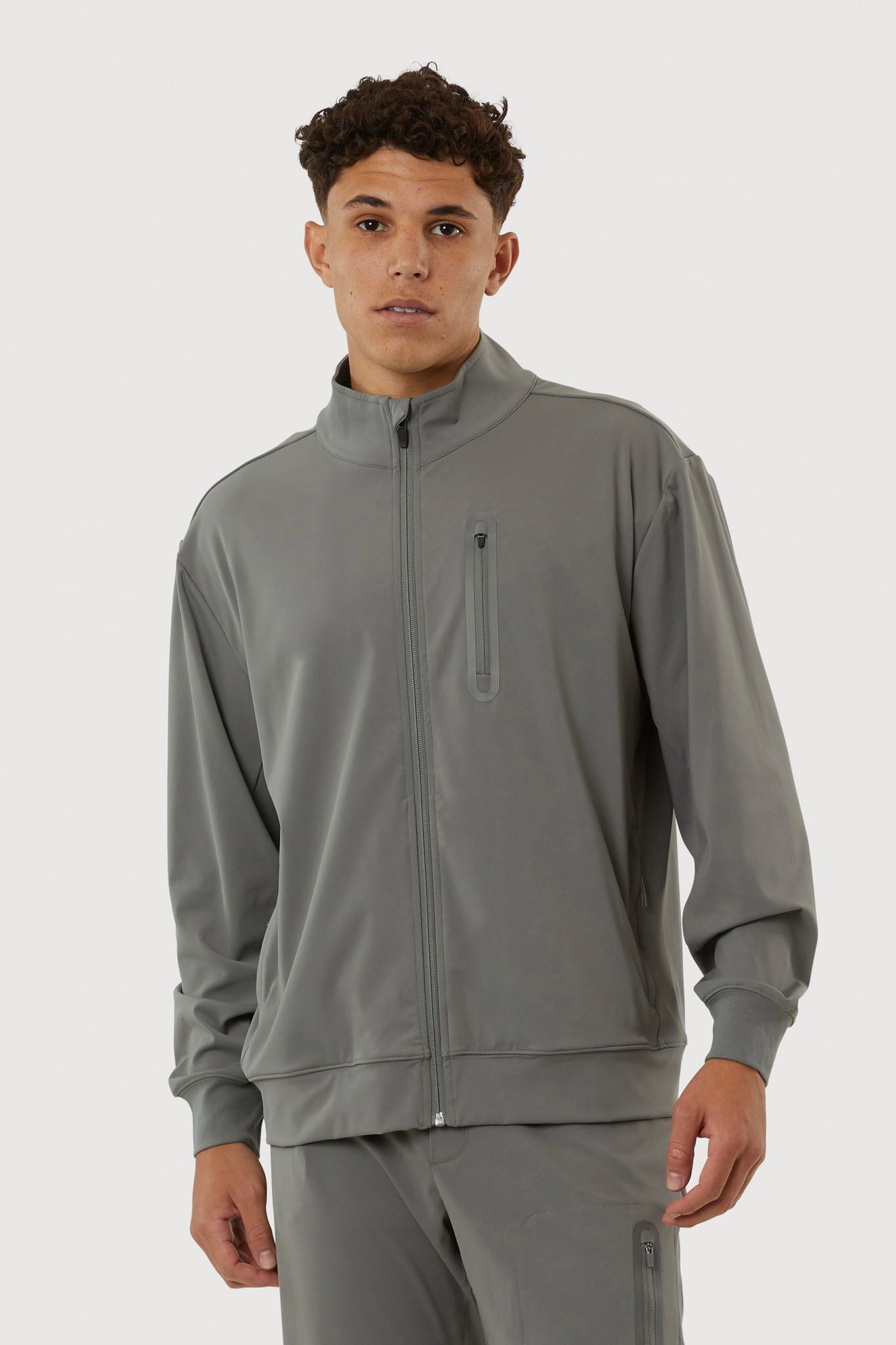 Man wearing a gray tracksuit on a white background