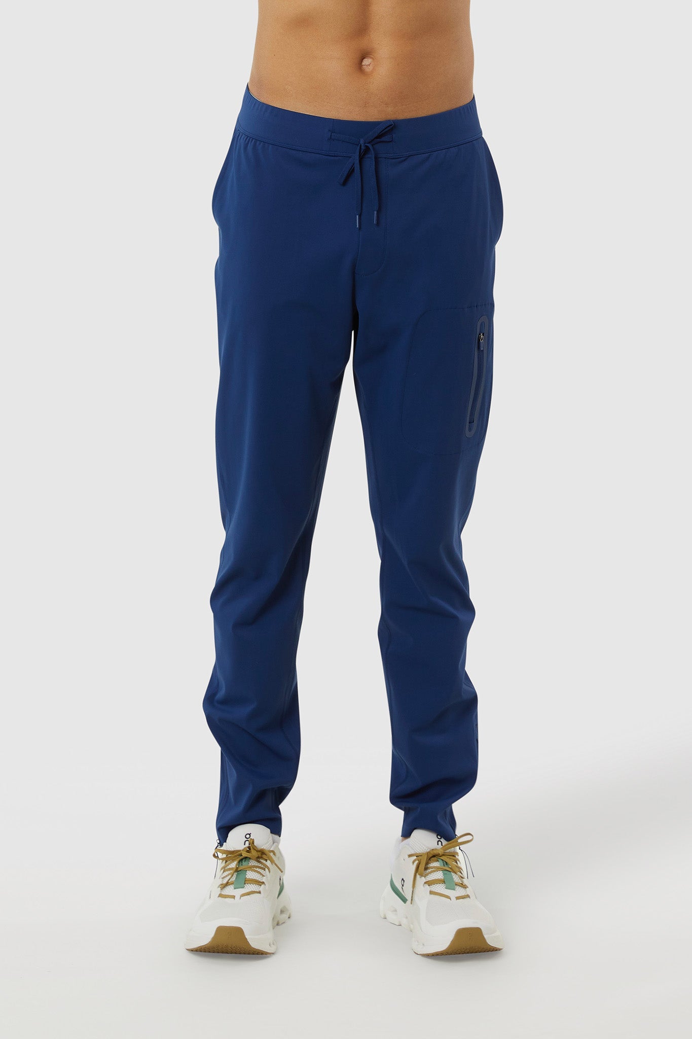 Blue jogger pants worn by a person on a white background