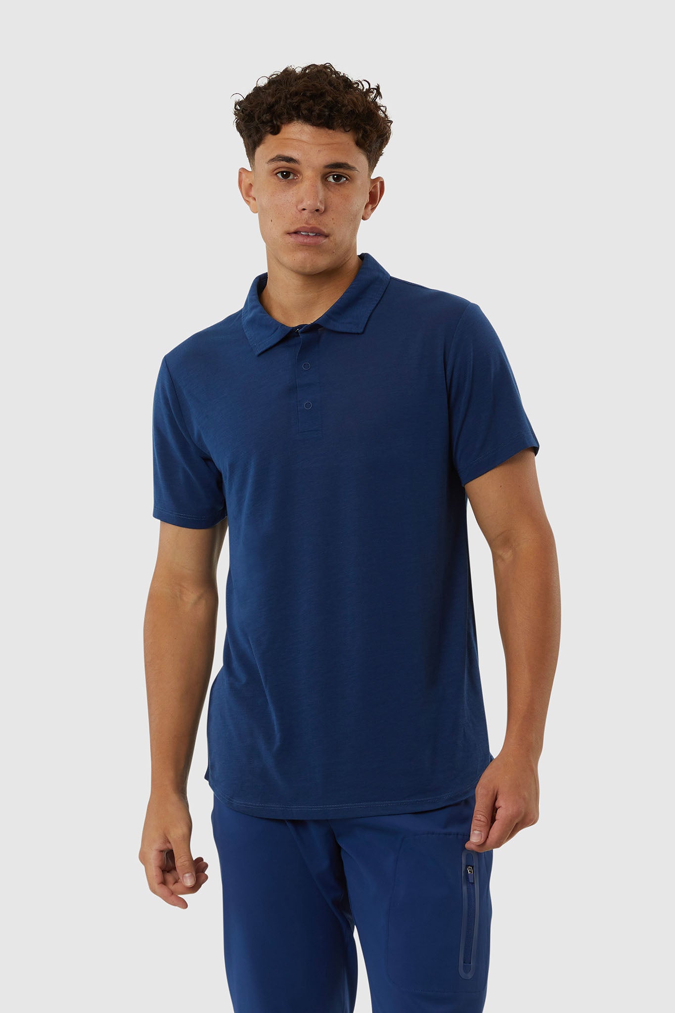 Man wearing a blue polo shirt and pants on a white background