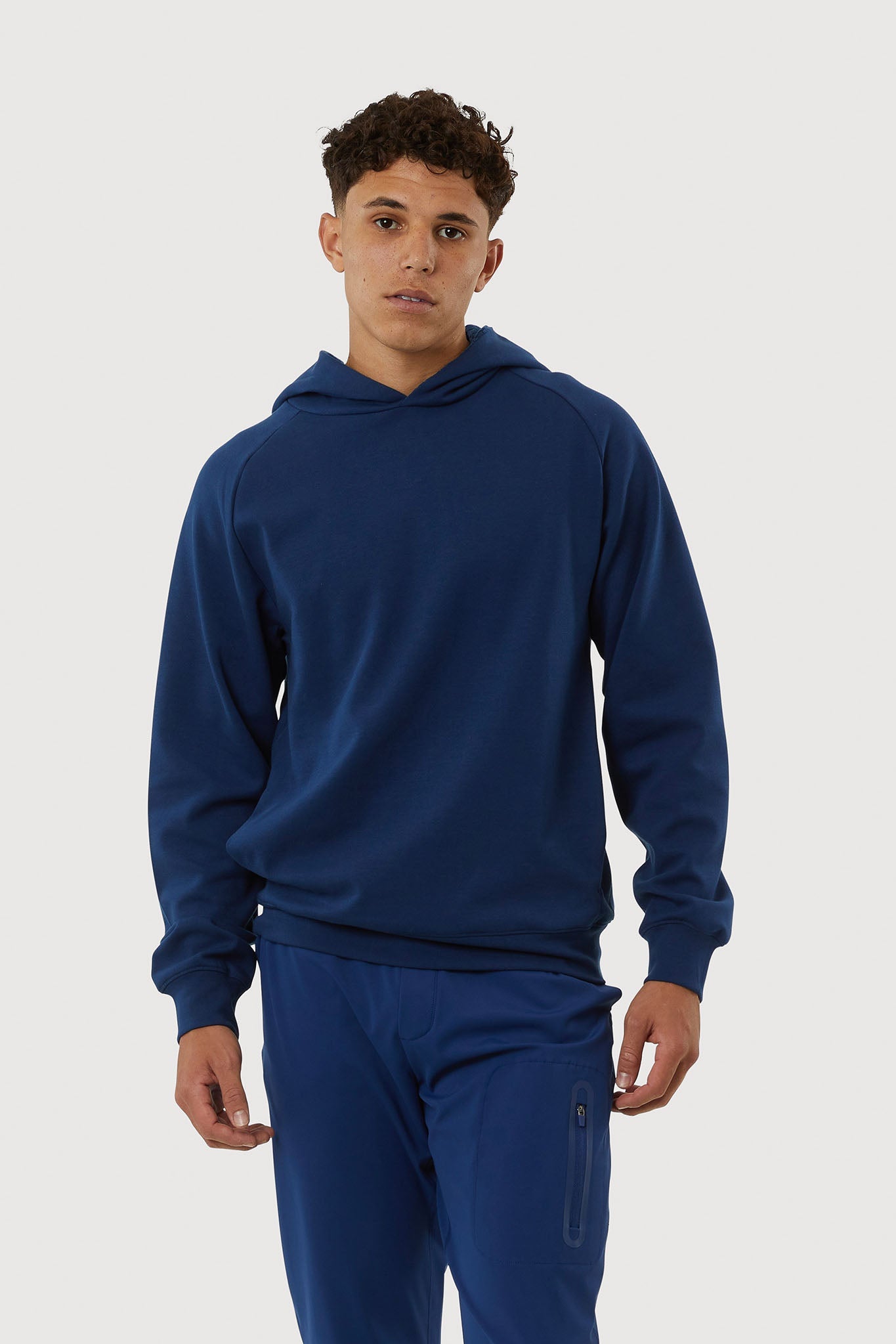 Man wearing a blue hoodie and pants on a white background