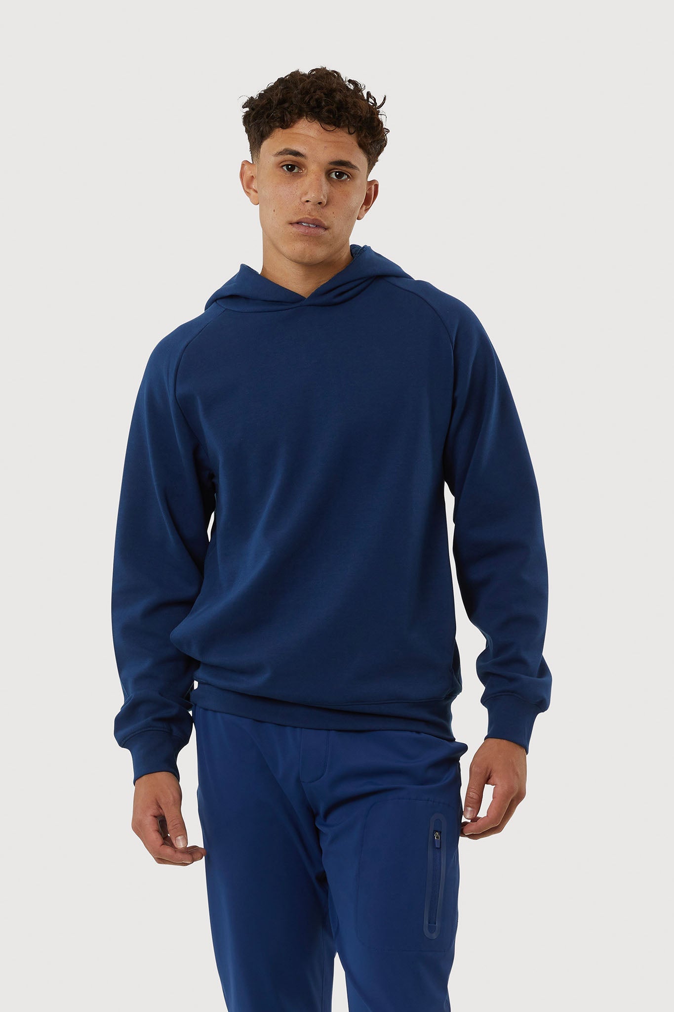 Man wearing a blue hoodie and pants on a white background
