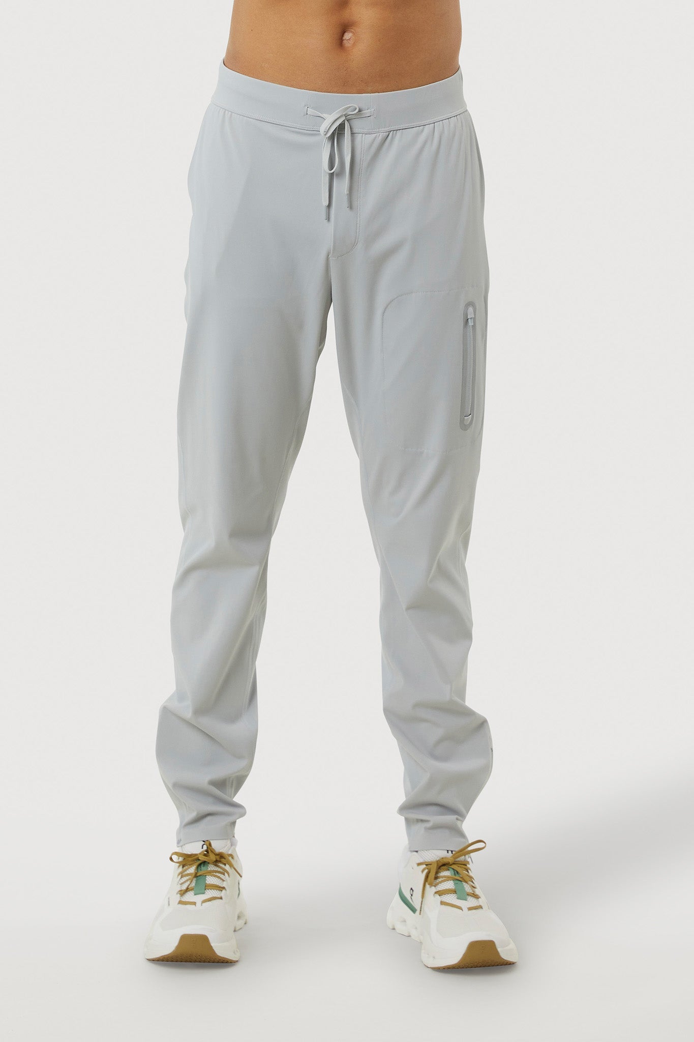 Light gray jogger pants worn by a person on a white background