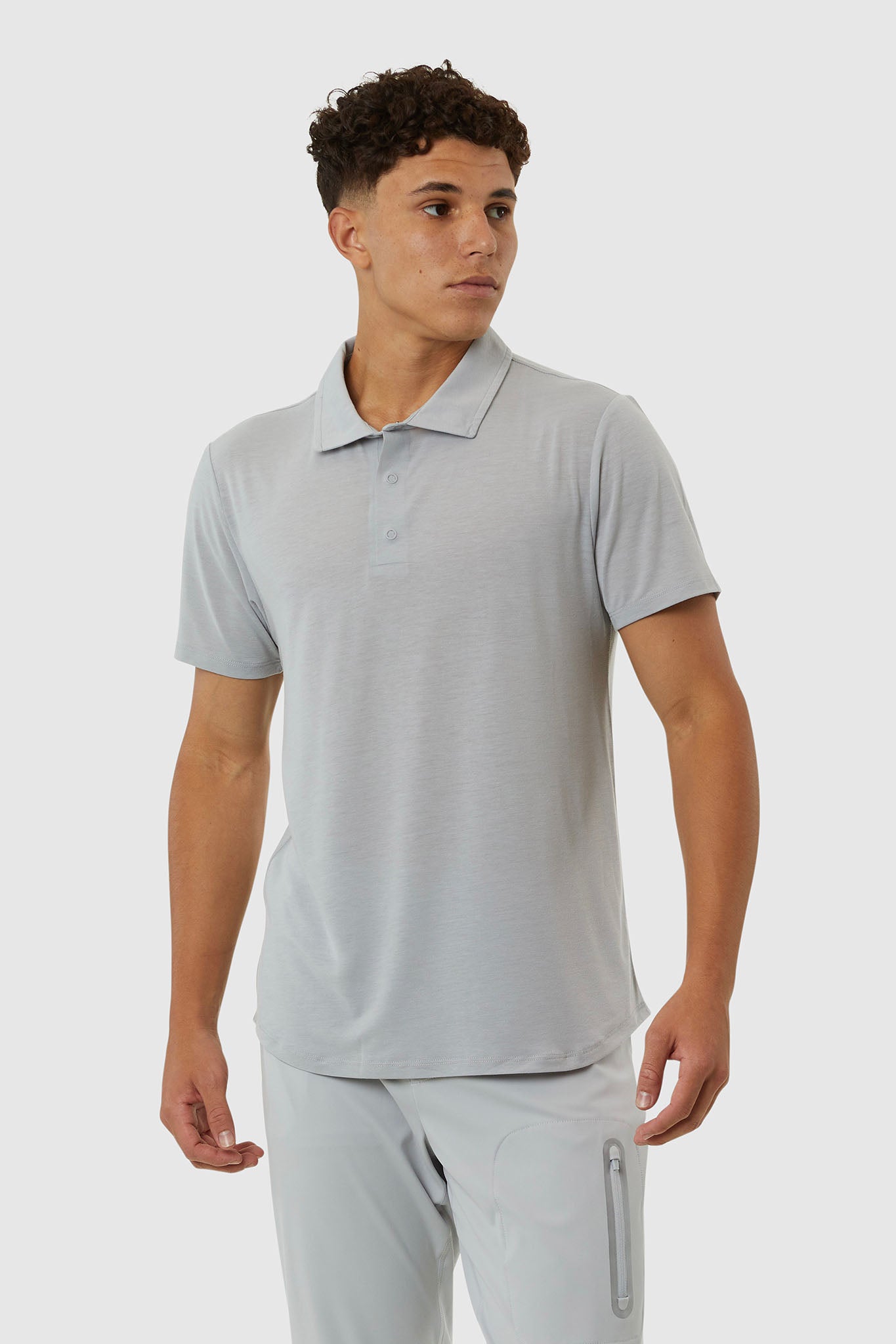 Man wearing a light gray polo shirt and pants on a white background