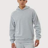 Person wearing a light gray hoodie and pants on a white background