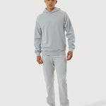 Person wearing a gray tracksuit on a white background