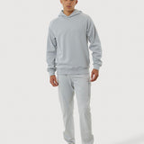 Person wearing a gray tracksuit on a white background