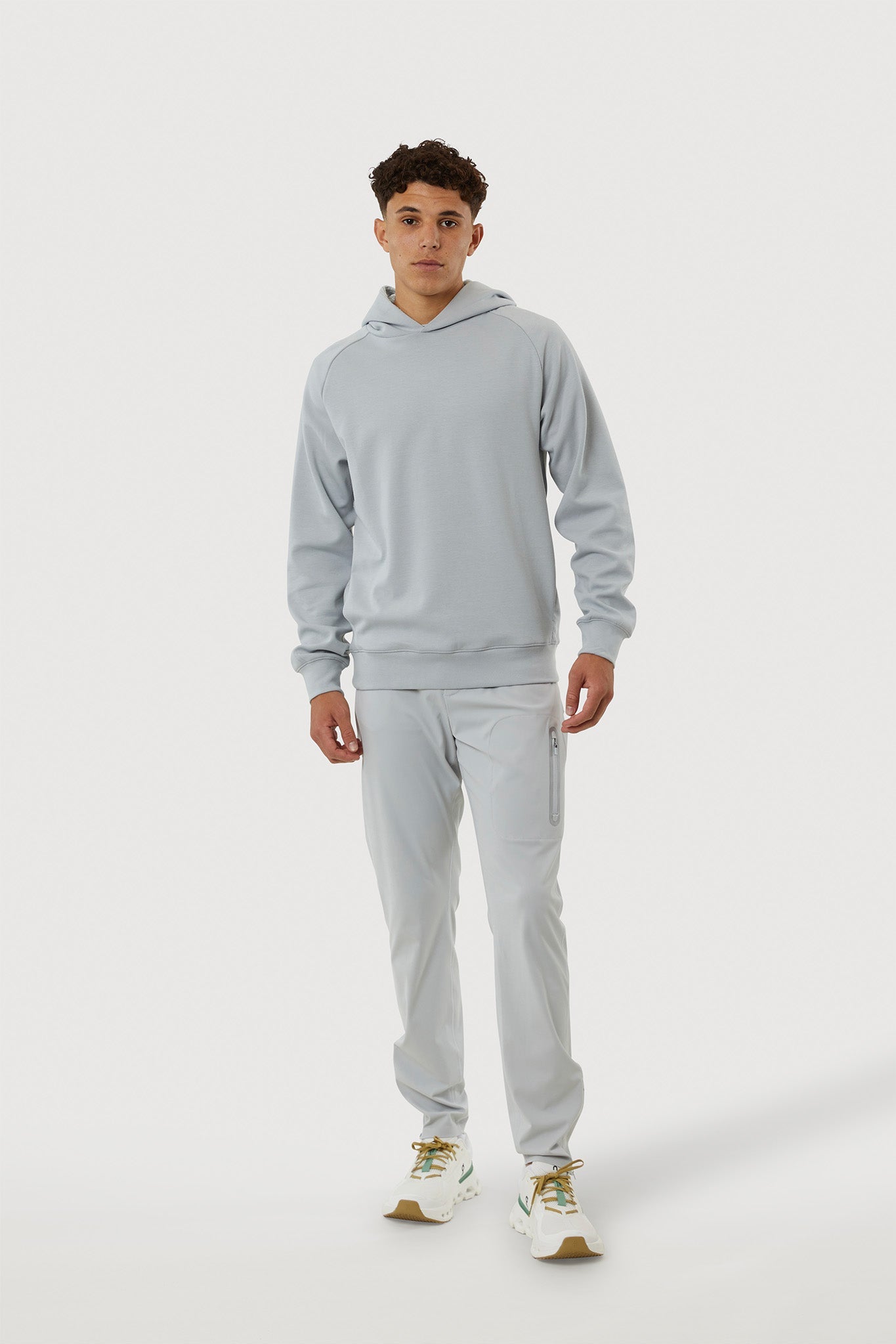 Person wearing a gray tracksuit on a white background