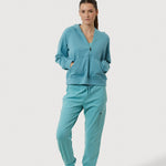 Woman wearing a teal tracksuit on a white background