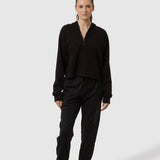 Person wearing a black outfit on a white background