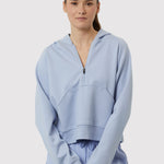 Person wearing a light blue hoodie and pants on a white background