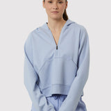 Person wearing a light blue hoodie and pants on a white background