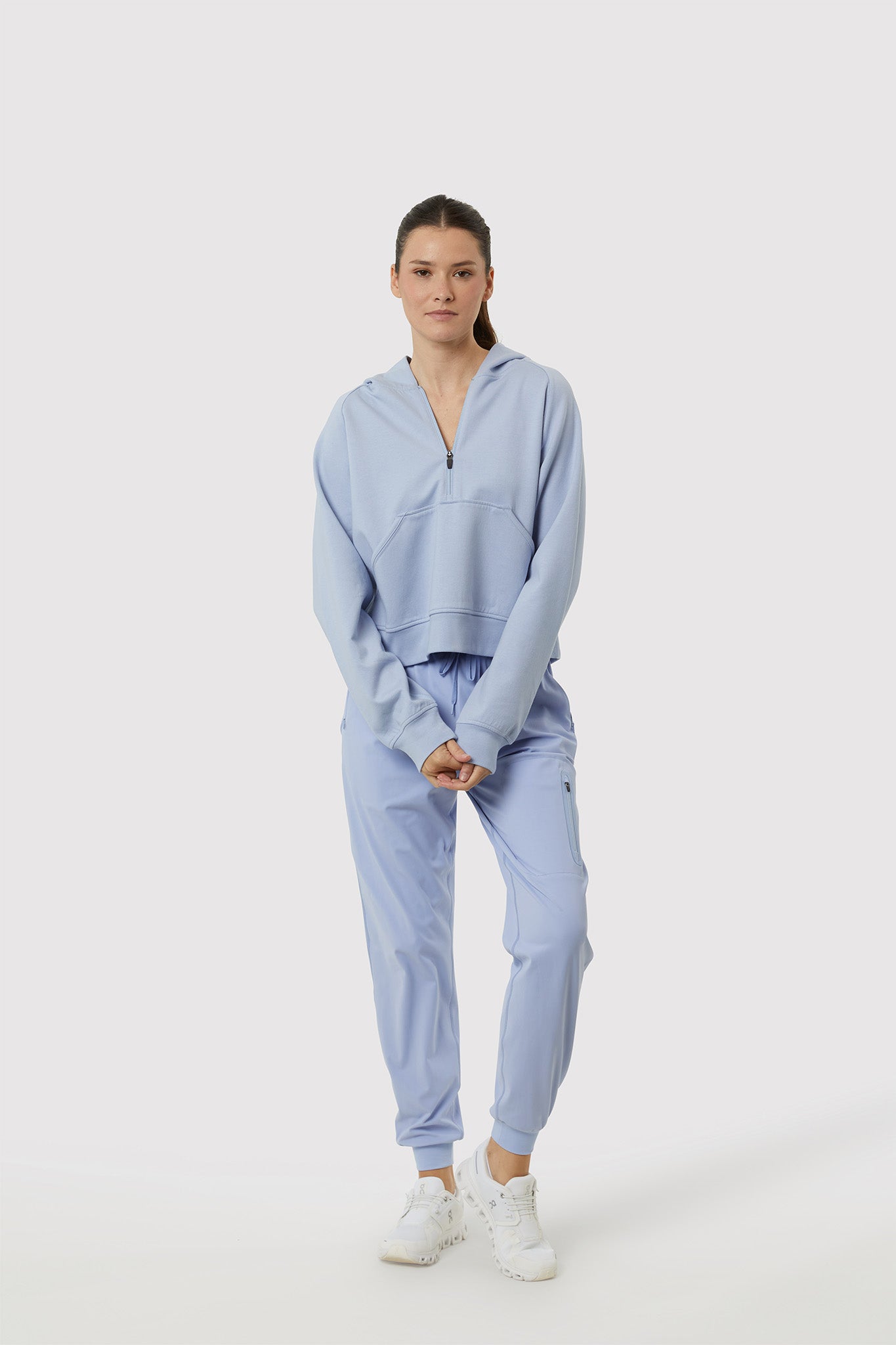 Woman wearing a light blue tracksuit on a white background