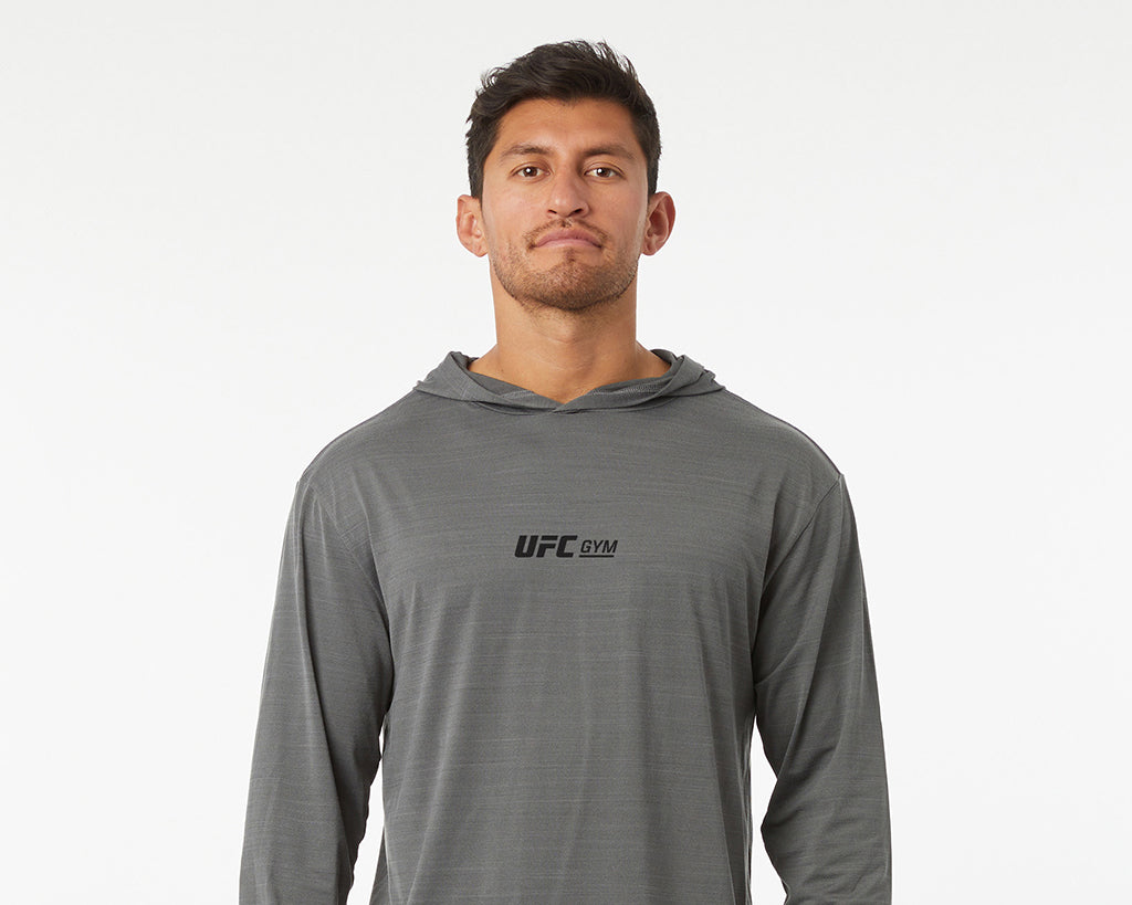 Man wearing a gray UFC Gym hoodie on a white background